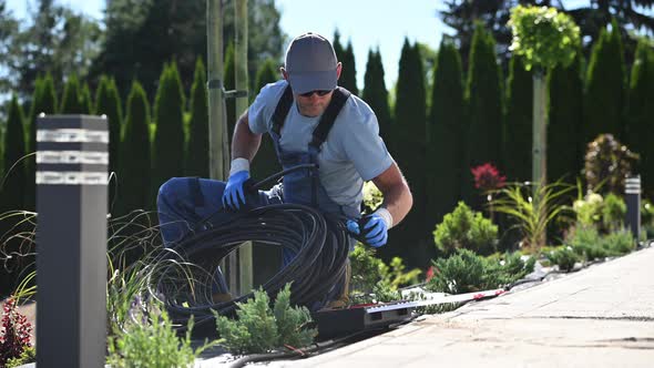 Landscaping Worker Preparing Trickle Irrigation Plastic Pipe alt