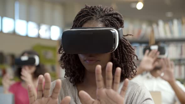 Slow Motion Shot of Focused Woman Wearing VR Glasses alt