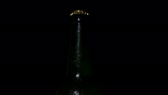 Cold Beer with Water Drops on the Bottle is Illuminated By Light From the Darkness
