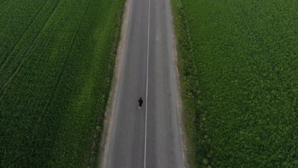 A Lone Female Runs Along a Narrow Road in the Middle of an Ocean of Greenery