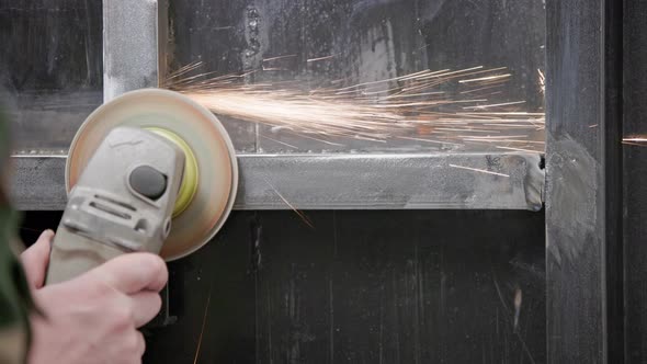 Caucasian Hand Cleaning of Welded Seams with an Angle Grinder with a Flap Disc on Welded Metal alt