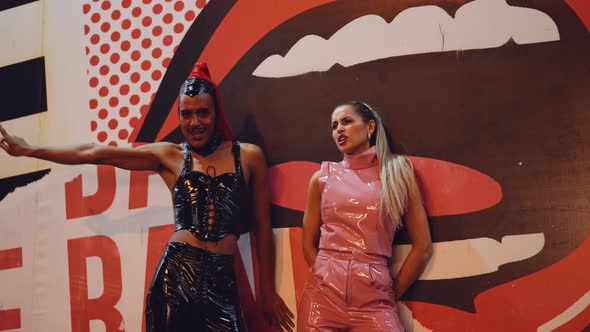 Young Woman And Man In Pvc Clubwear Dancing And Singing By Graffiti alt