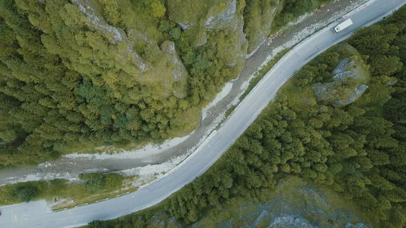 Top Panoramic Aerial View of a Truck Moving on a Mountain Road in a Beautiful Deep Gorge alt