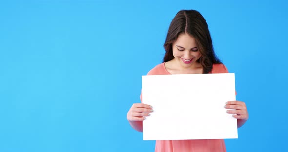 Beautiful woman holding blank placard on blue background alt