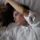Sexy Brunette Girl Lies on a White Bed Plays with Her Hair - VideoHive Item for Sale