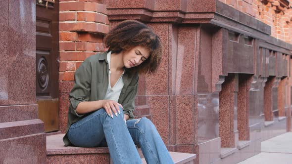 African American Woman Holding and Massaging Her Leg Because of Injury alt