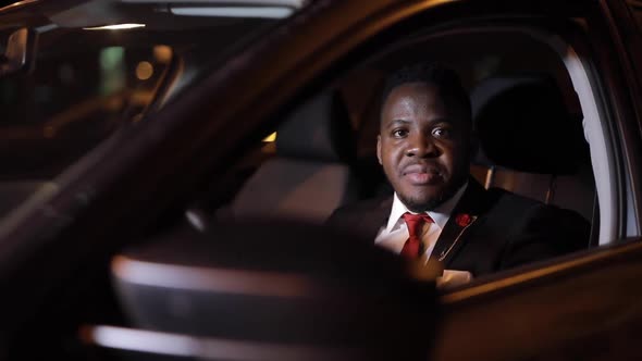 African Successful Businessman Sitting in a Car at Night City