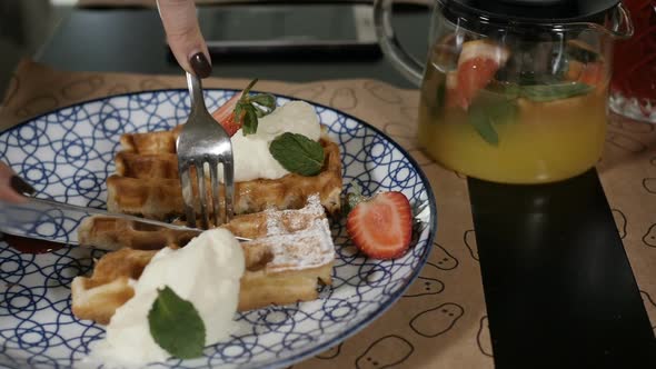 Women's Hands Beautifully Cut Waffles with Cream and Fruit