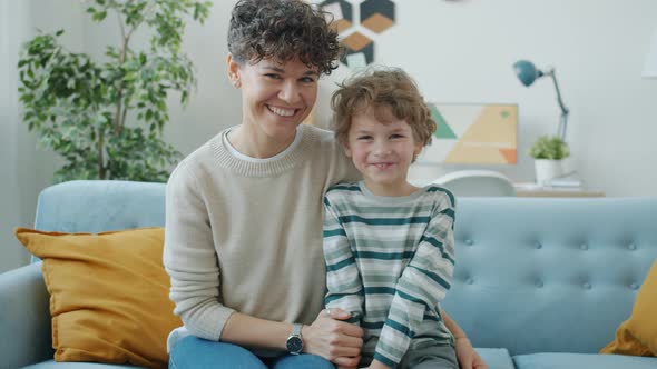 Portrait of Happy Young Family Mother and Son Smiling Indoors at Home alt