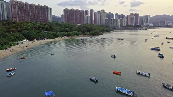 A dynamic aerial footage of various boats near the beach of Sai Kung town in Hong Kong. The Sai Kung alt