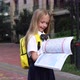 Happy Little Caucasian Blonde Girl Seven Years Old in Uniform with Yellow Backpack Reading Book Near - VideoHive Item for Sale