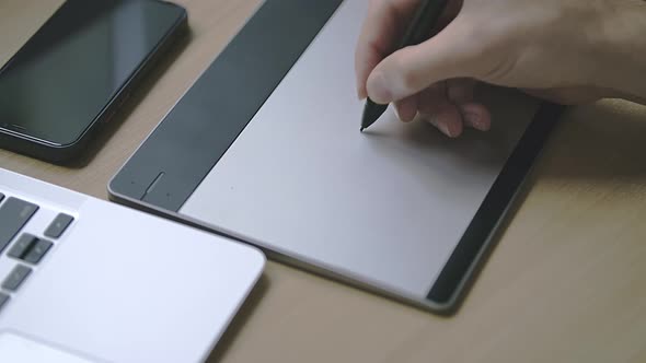 Male Caucasian Hand is Drawing Something on a Graphic Tablet