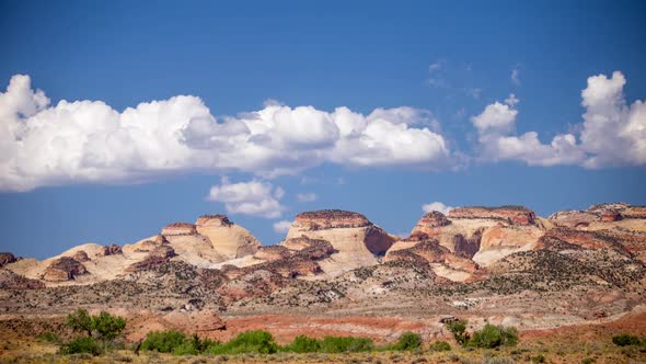 Time lapse of clouds moving across the sky over desert cliffs alt