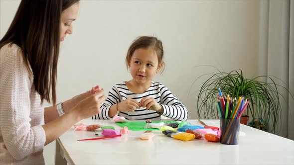 Mother and Daughter Playing with Modelling Clay Together alt