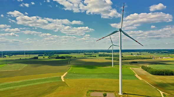 Wind turbines and green field in summer day alt
