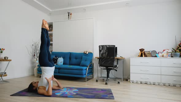 Young Woman Does Supported Shoulderstand Yoga Pose At Home
