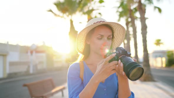 Photographer Tourist Woman Taking Photos with Camera in a Beautiful Tropical Landscape at Sunset alt