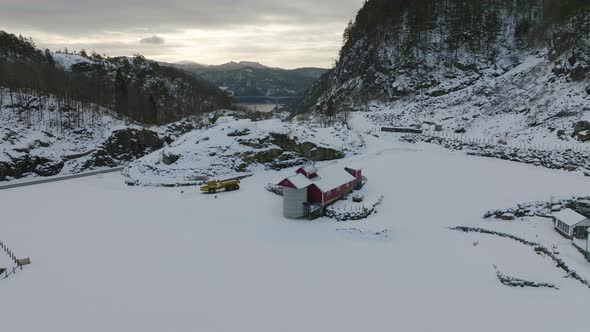 Red and white houses in snow covered valley. Refuge in snowy landscape. Sunset alt