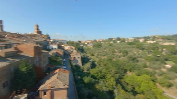 Flock of birds over a medieval village in the Tuscan hills. Sinalunga, Italiy. Aerial view alt
