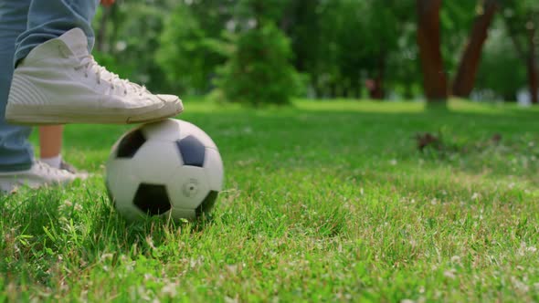 Unknown Human Legs Kicking Ball on Grass Closeup alt