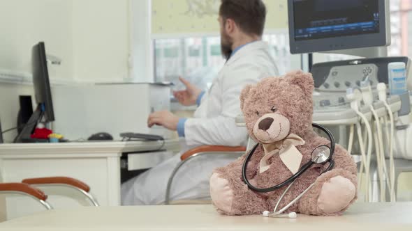 Male Pediatrician Examining Mri Scan, Plush Toy Teddy Bear on the Foreground alt
