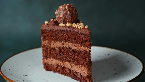 Piece of chocolate cake. Cake rotating. Chocolate dessert. Coffee cake on white plate.