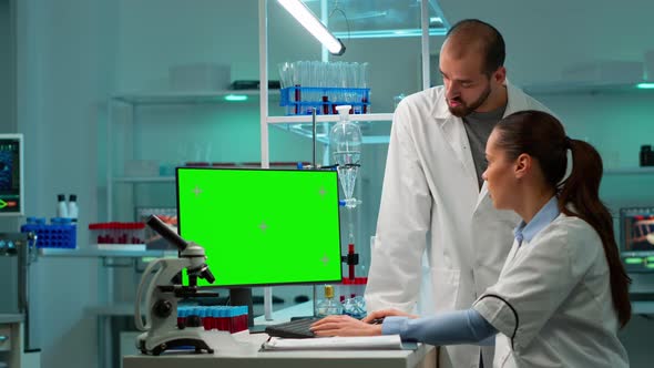 Scientists Discussing in Front of Computer with Green Chroma Key Screen alt