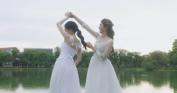 Happy Asian Lesbian Married Couple Dancing In The Park. alt
