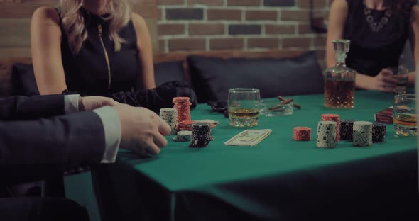 Man Mixes and Distributes a Deck of Cards. Company Plays Poker. Gaming Chips, Money, Cigars alt
