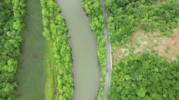 Flight with drone over a road around a river alt