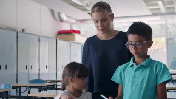 Friendly Female School Teacher Watching Pupils alt