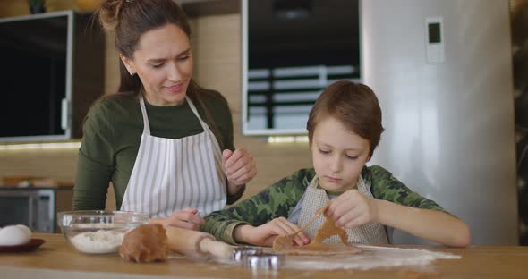 Happy Mother and Son Cooking Cookies Together in the Kitchen alt