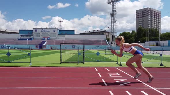 Young Woman Runner at the Stadium Starts Running the Distance alt