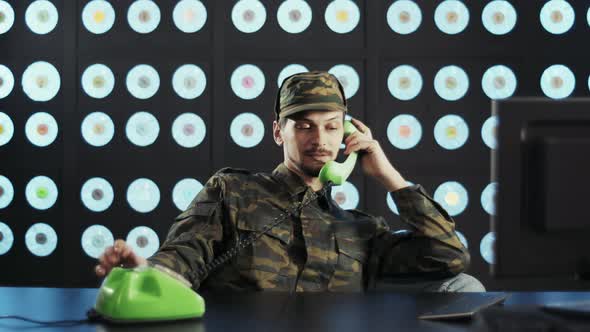 Bored Military Guy is Speaking to Someone Via Oldfashioned Green Telephone