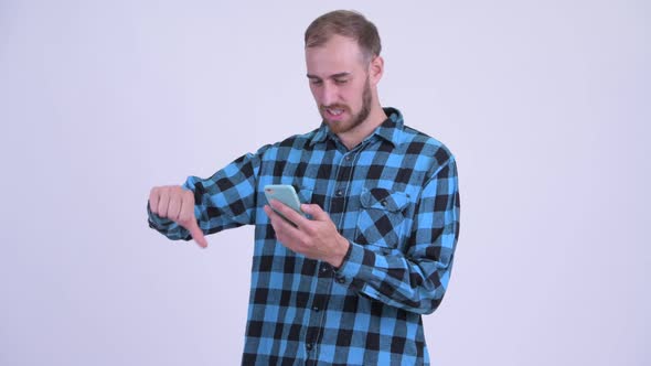Stressed Bearded Hipster Man Using Phone and Getting Bad News alt