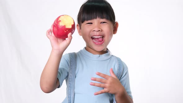 Happy little girl with apple. alt