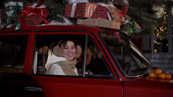 Smiling Woman Together Man Inside Christmas Car Opening Window alt