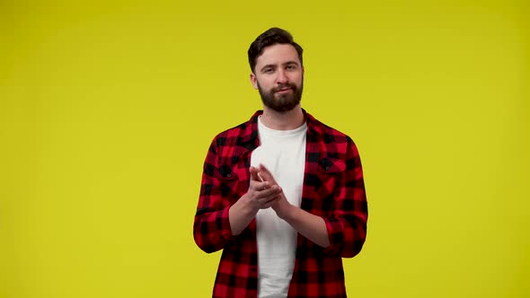 Portrait of a Man Applauding with His Hands on Yellow Studio Background alt