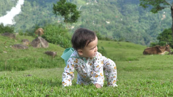 On a Green Grassy Plain a Child in a Summer Suit Moves Paying Attention to What is Happening in the