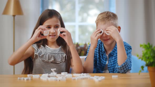 Portrait of Happy Kids Having Fun with Plastic Letters Sitting at Table alt