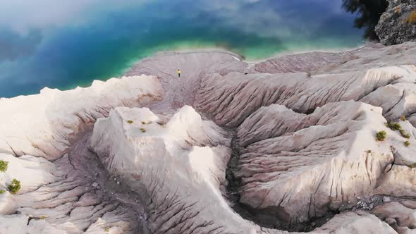 A Woman Stands on the Shore of a Beautiful Lake alt