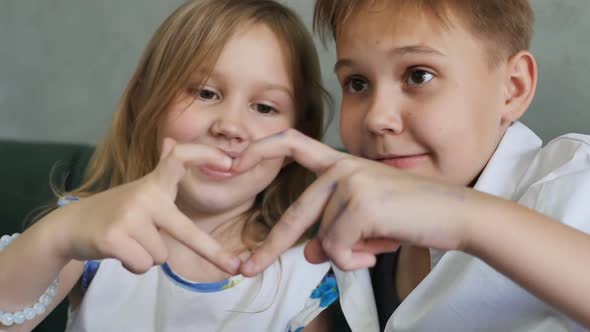 Two Caucasian Teenage Girls Made a Joint Sign of the Heart with Their Fingers By Joining Their Hands alt