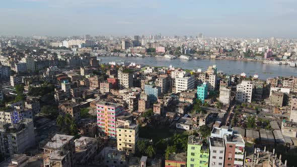 Aerial flight over populous city of Dhaka; view of boat traffic on Buriganga river - drone flight fo alt