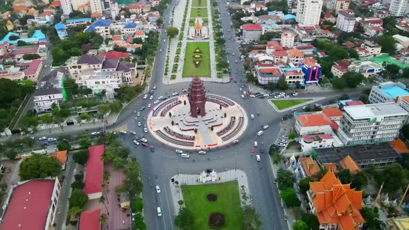 Aerial top down shot of famous Independence Monument and cars driving in roundabout during daylight. alt