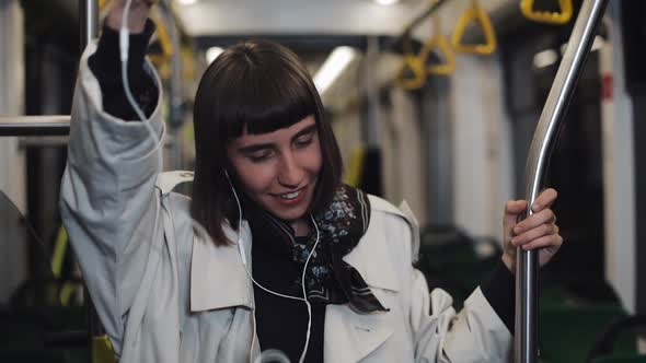 Portrait of Young Woman Wearing in Coat with Headphones Listening To Music and Funny Dancing in alt