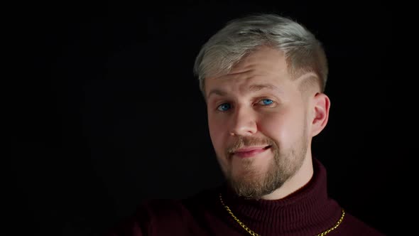 Smiling Man in Stylish Blouse Looking Approvingly at Camera Showing Thumbs Up on Black Background alt