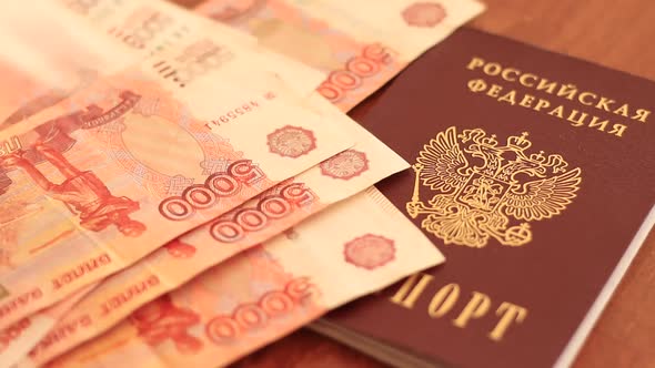 Hands Putting Russian Rubles Near The Passport Of Russian Federation