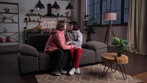 Caring Mother Hugging Handicapped Child Indoors alt