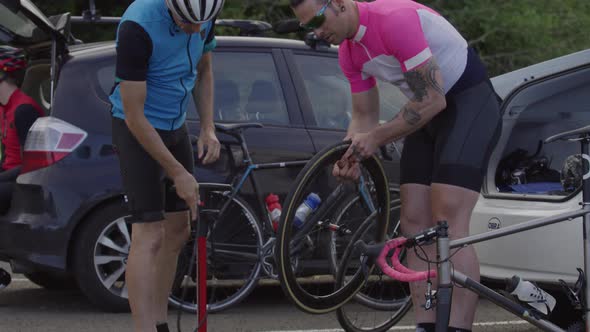 Cyclists fixing tire and preparing bicycle for ride.  Fully released for commercial use.