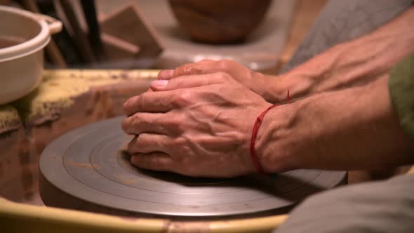 Close-up of a Man Potter Kneading Clay Beats It for Installation on a Potter's Wheel alt
